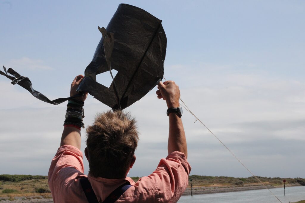 Peter Quinell holds a kite at Rye Harbour